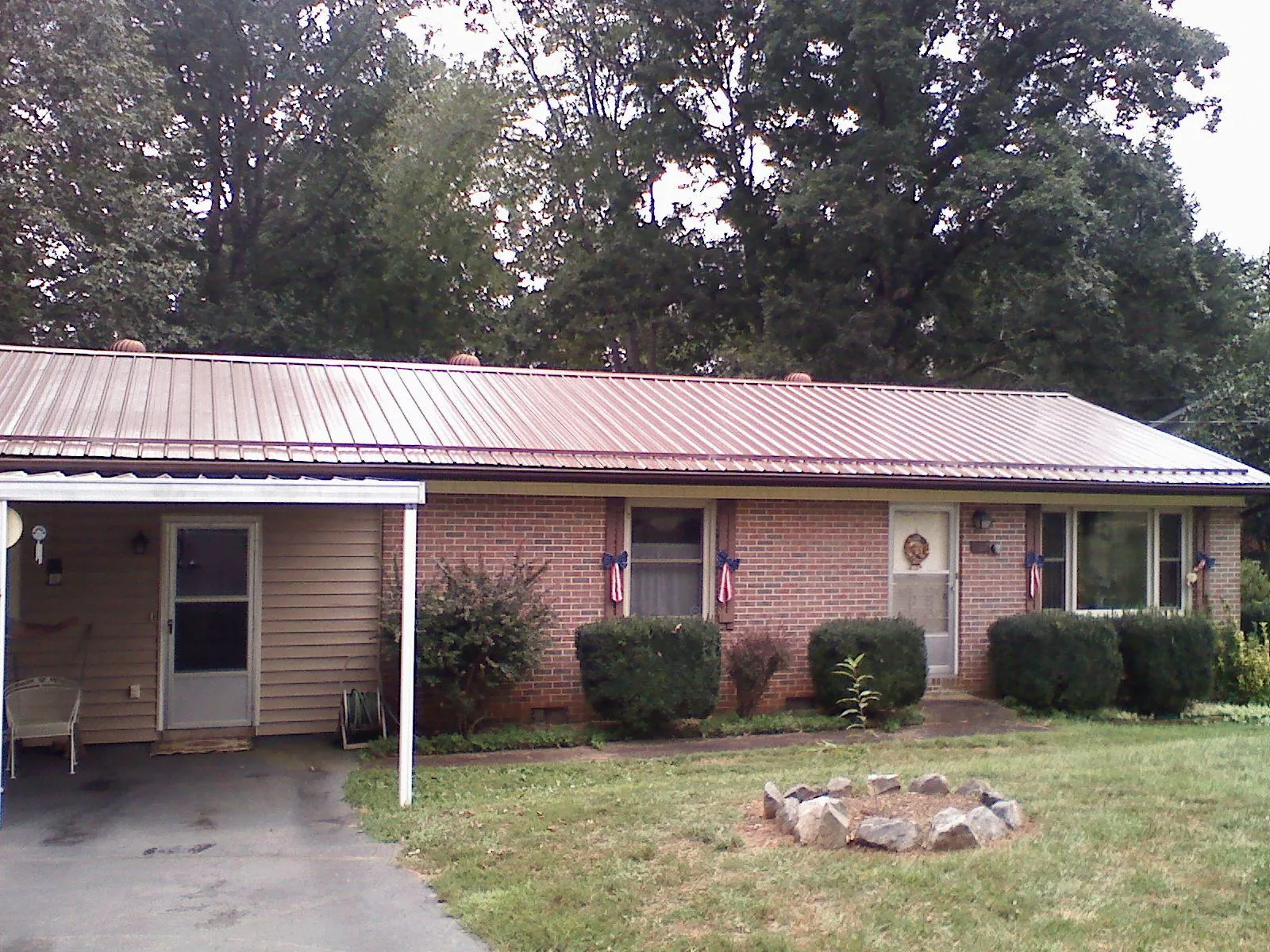 Bronze metal roof and carport on a brick ranch home — Roof Repair work by our crew in Clara City